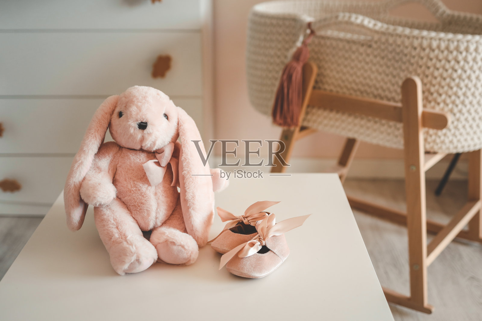 粉色毛绒玩具兔和婴儿拖鞋，儿童概念照片摄影图片