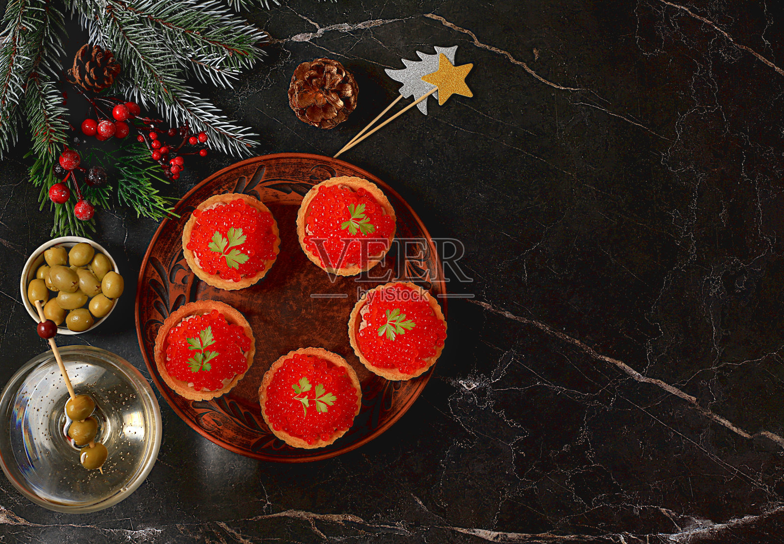 圣诞节和新年的菜肴，一套小吃的节日餐桌。混凝土桌上放着一盘肉饼和红鲑鱼鱼子酱，照片摄影图片