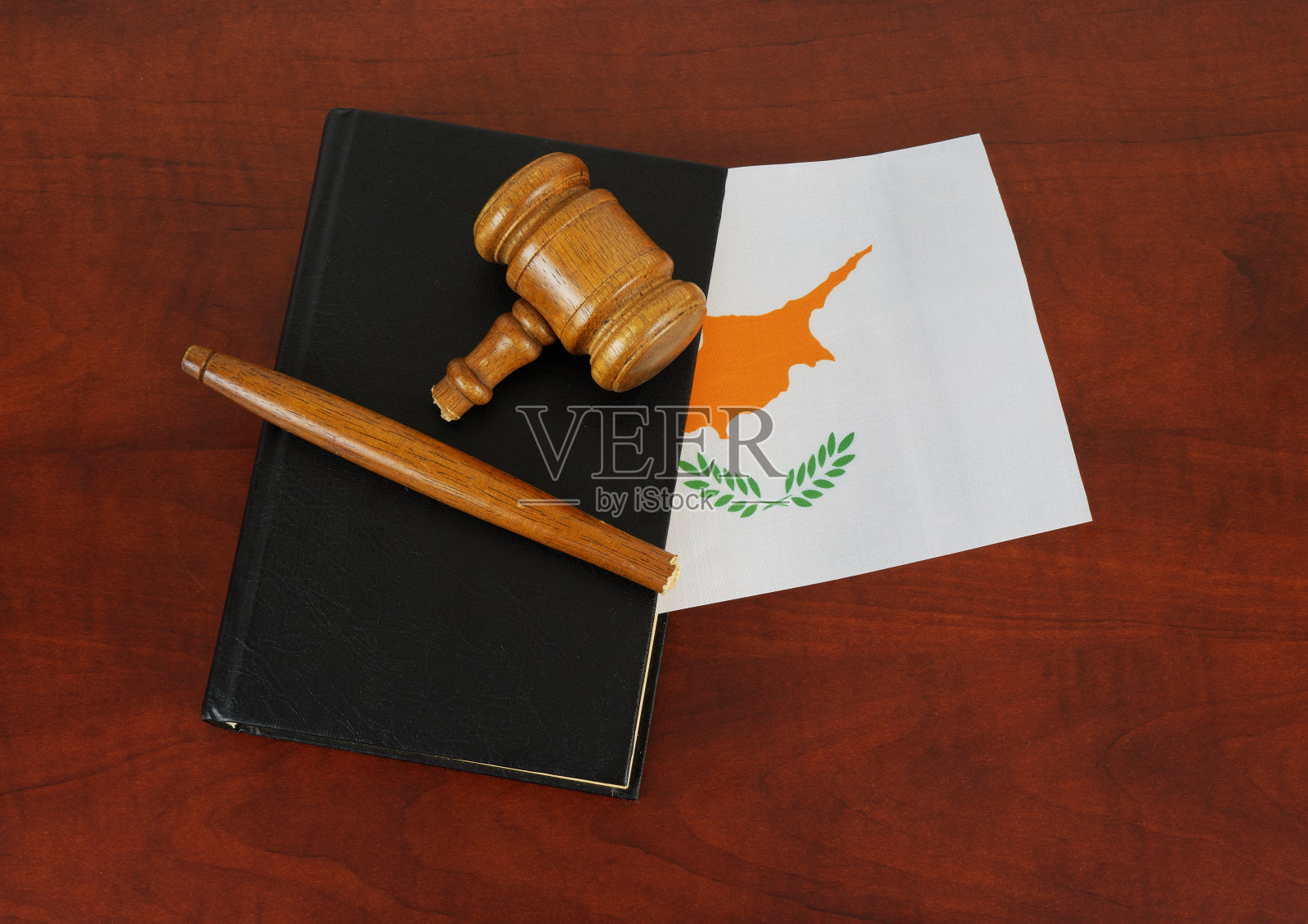 破碎的法官木槌和带有塞浦路斯国旗的法律书。照片摄影图片