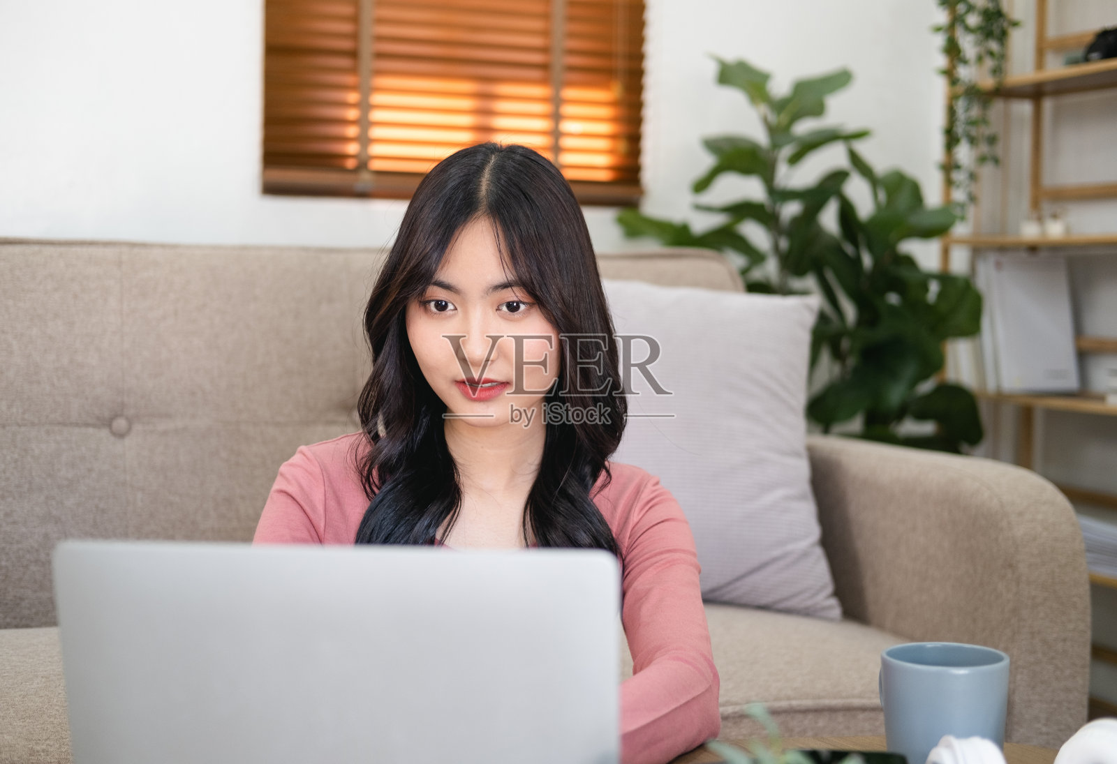 头像愉快快乐的年轻女性自由职业者在家里工作的电脑。有吸引力的商务女性在网上学习，使用笔记本电脑软件，网上冲浪信息或在网上商店购物。照片摄影图片