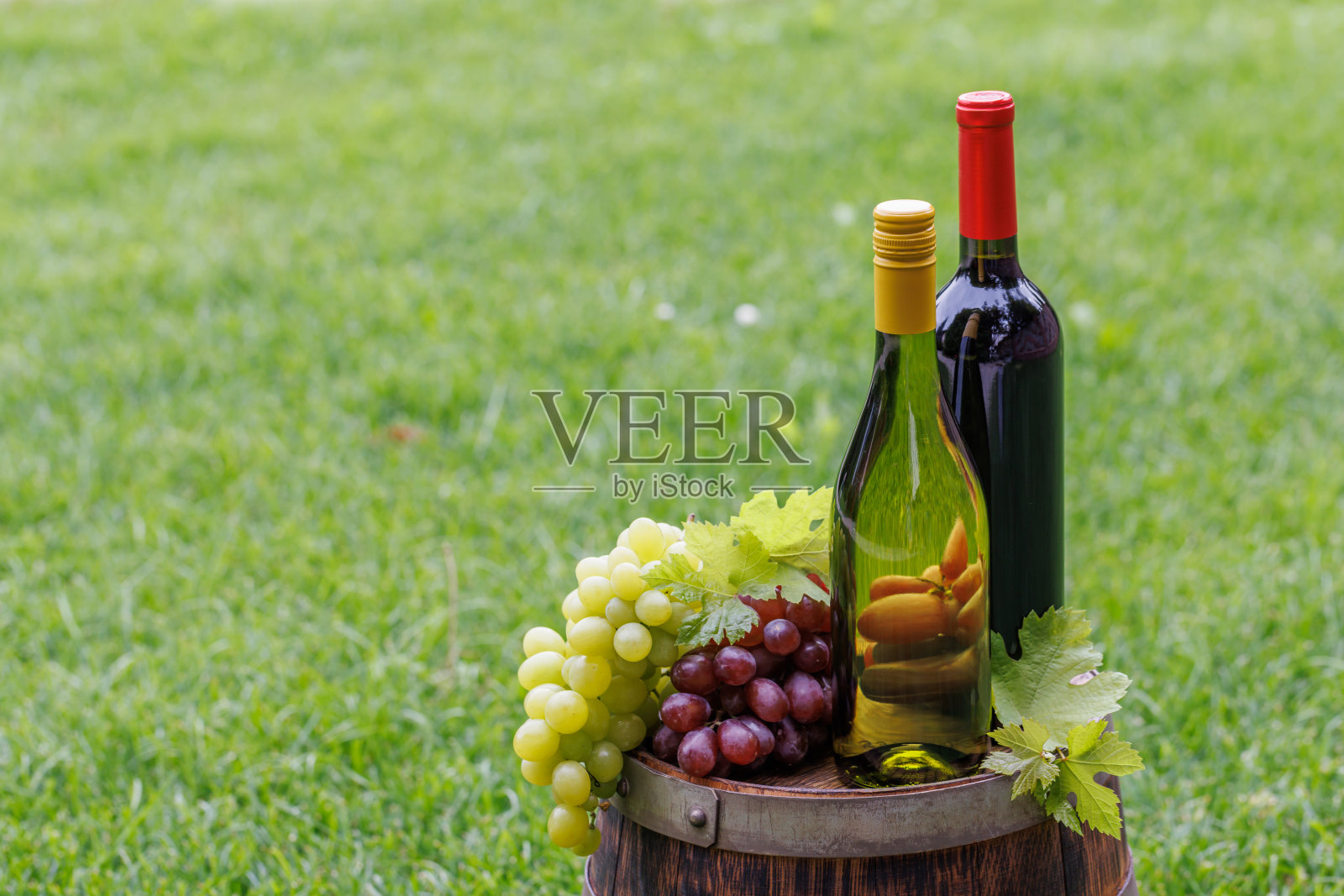 酒瓶和酒桶上的葡萄照片摄影图片