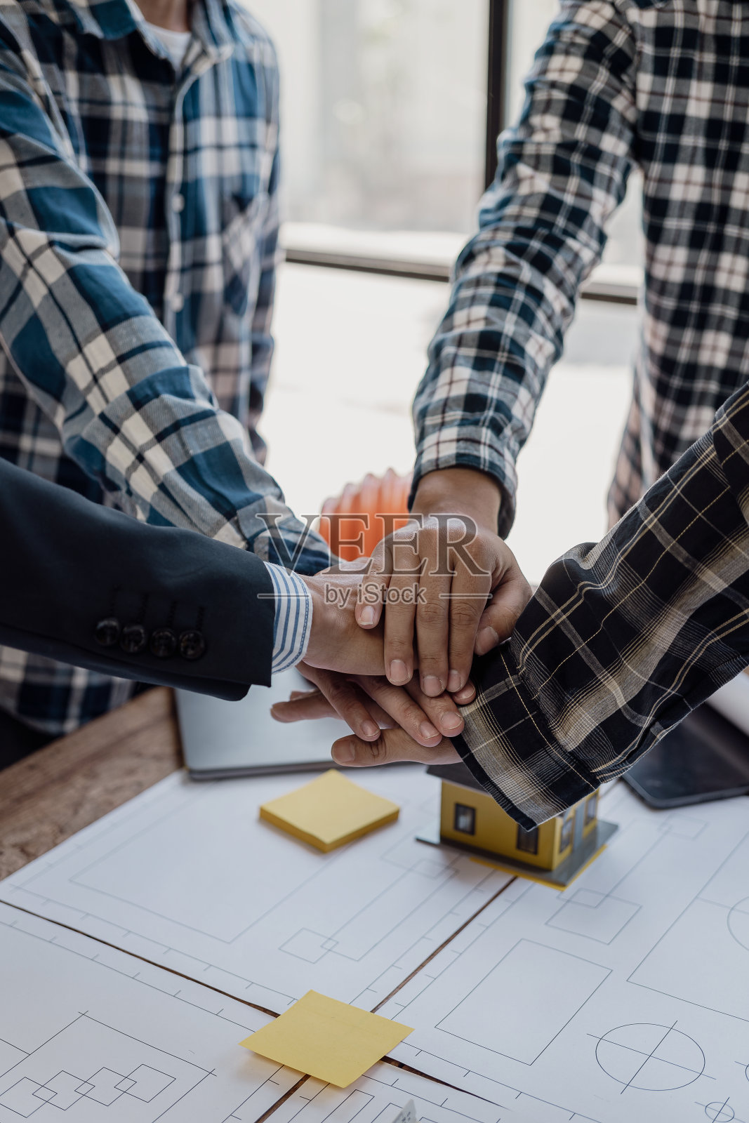 建筑工人互相握手致意。戴着防护头盔、身穿背心的建筑工人正在握手。商业，建筑，团队合作，人的手势和概念。照片摄影图片