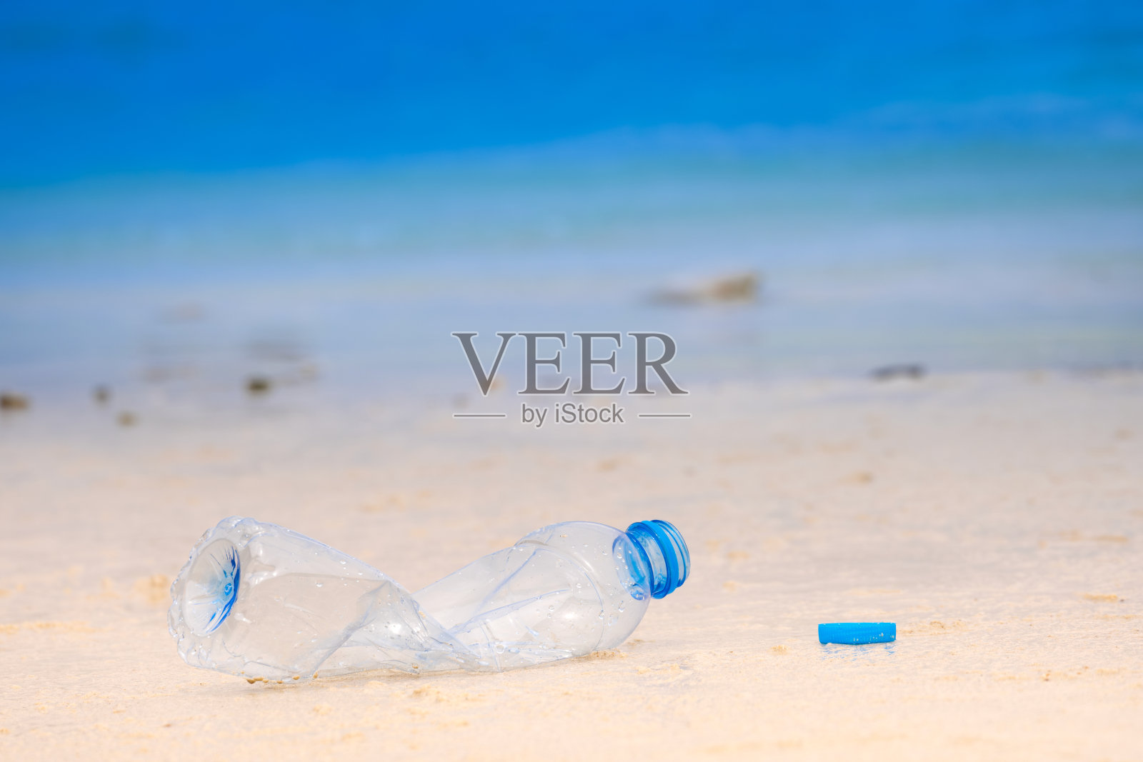 在海滩上扔瓶装水产生海洋垃圾问题，对生态环境产生影响照片摄影图片