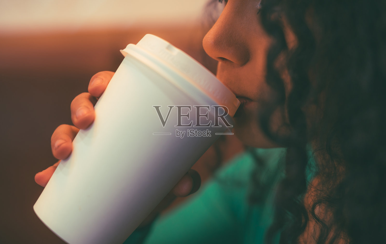 卷发的黑发女孩在享受一杯咖啡照片摄影图片