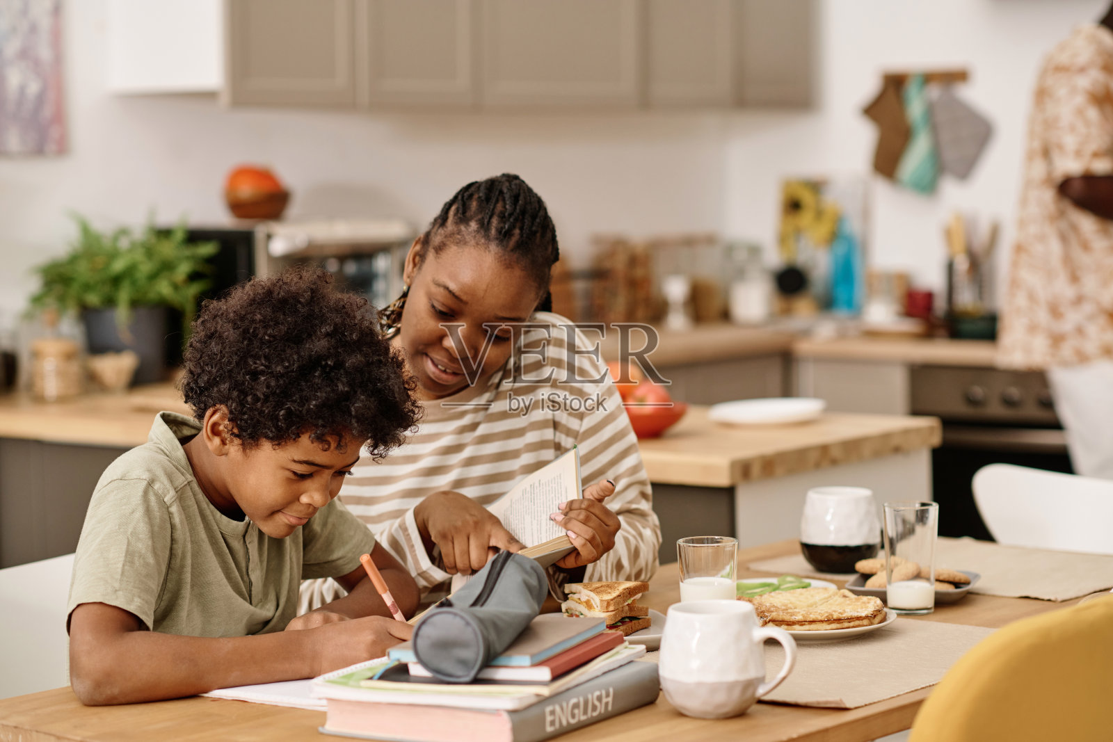帮助儿子做家庭作业的妇女照片摄影图片