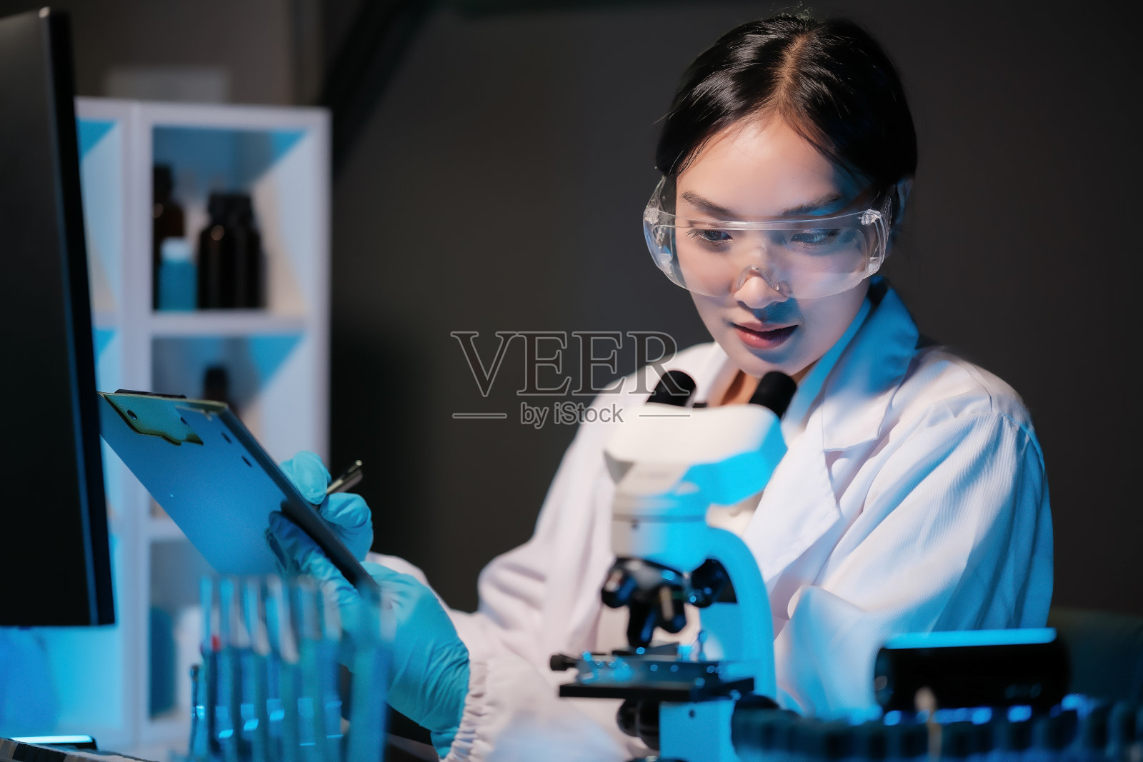 亚洲女科学家在显微镜下分析培养皿样本。从事医学、生物技术研究的专家在先进的药学实验室、医学开发实验室。照片摄影图片