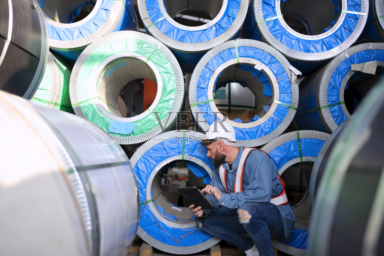 在金属片厂工作的蓝领工人。照片摄影图片