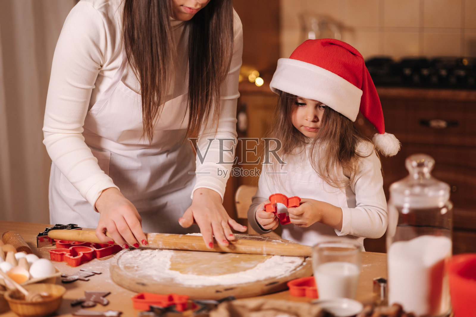 妈妈和女儿用擀面杖做姜饼。姜饼生面团的俯视图。圣诞节的心情。为假期做准备照片摄影图片
