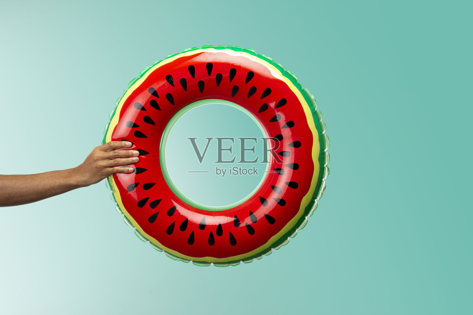 充气游泳环，看起来像西瓜孤立在绿松石背景渐变到更轻照片摄影图片