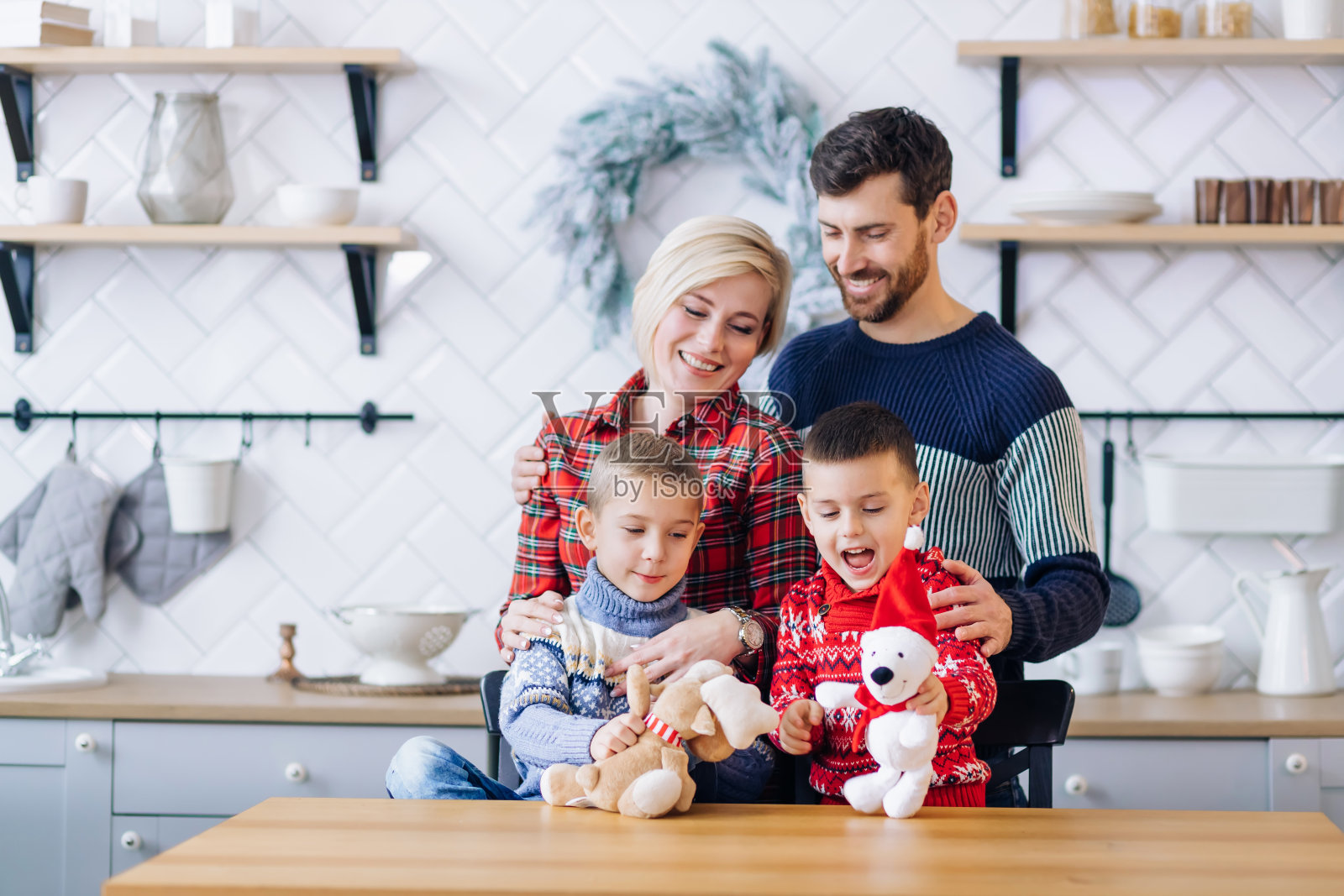 ． 快乐而慈爱的父母站在孩子身后，看着他们玩玩具照片摄影图片