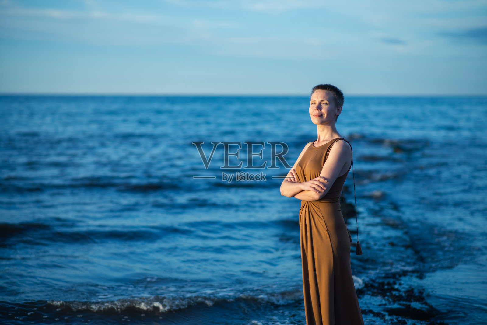 大海上心满意足的中年女人。一个短发的女人在微笑。照片摄影图片