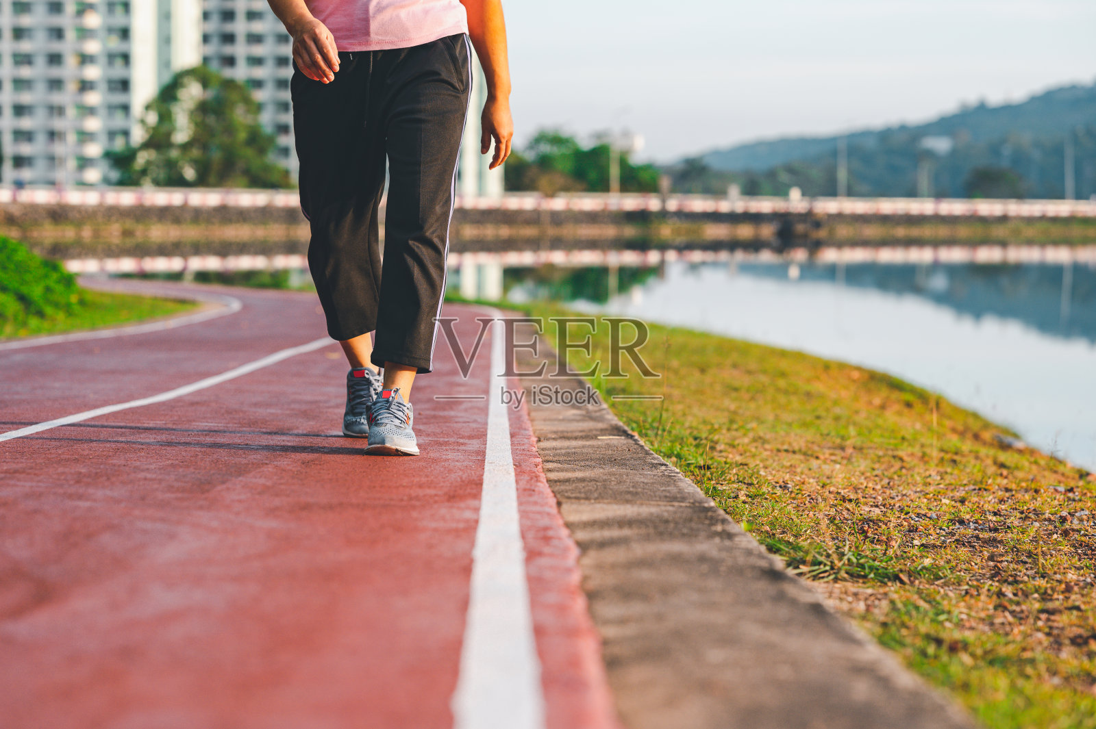 运动，锻炼理念。跑步的女运动员穿着跑鞋跑步，早上在体育场的跑道上慢跑。人们的健康和生活方式的锻炼。夏天到自然公园户外锻炼照片摄影图片