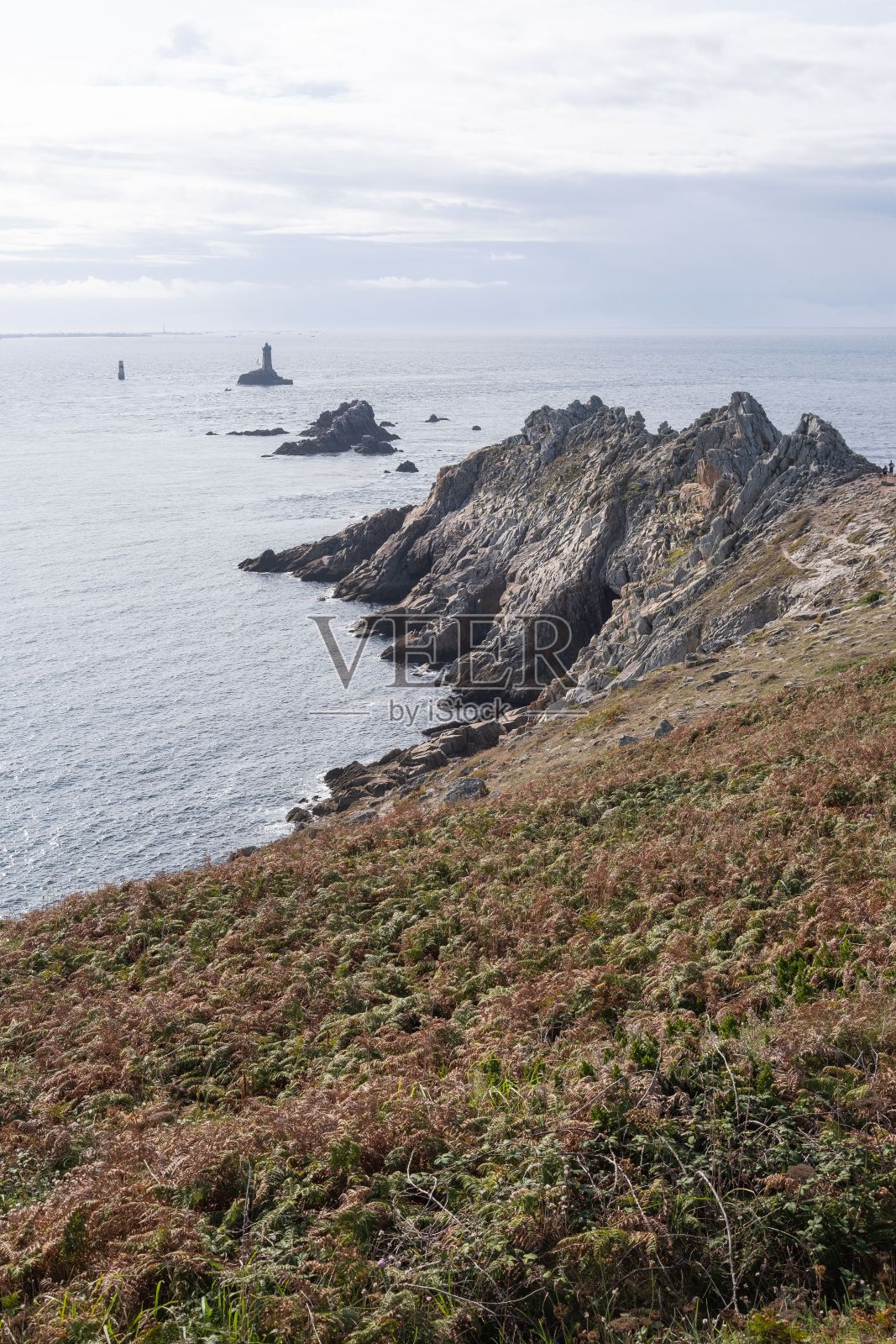 以宁静的海水为背景的岩石海岸线。法国布列塔尼照片摄影图片