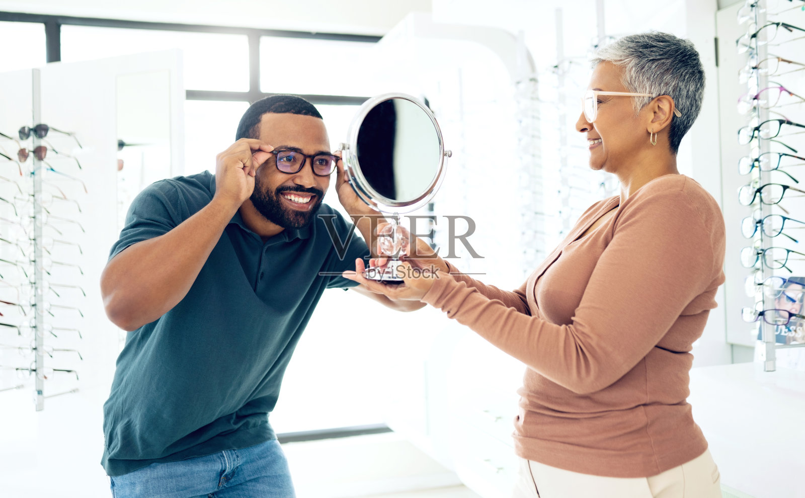 镜子，眼镜和验光师帮助快乐男人选择镜片，框架和咨询。微笑，反思和成熟的配镜师与病人一起戴眼镜，健康的视力和眼科照片摄影图片