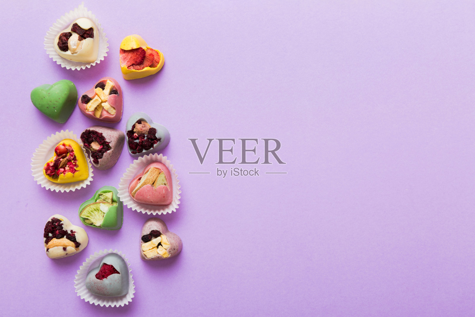 巧克力糖果，心形形状，水果和坚果在彩色背景上。顶视图与空间的文字，假期的概念照片摄影图片