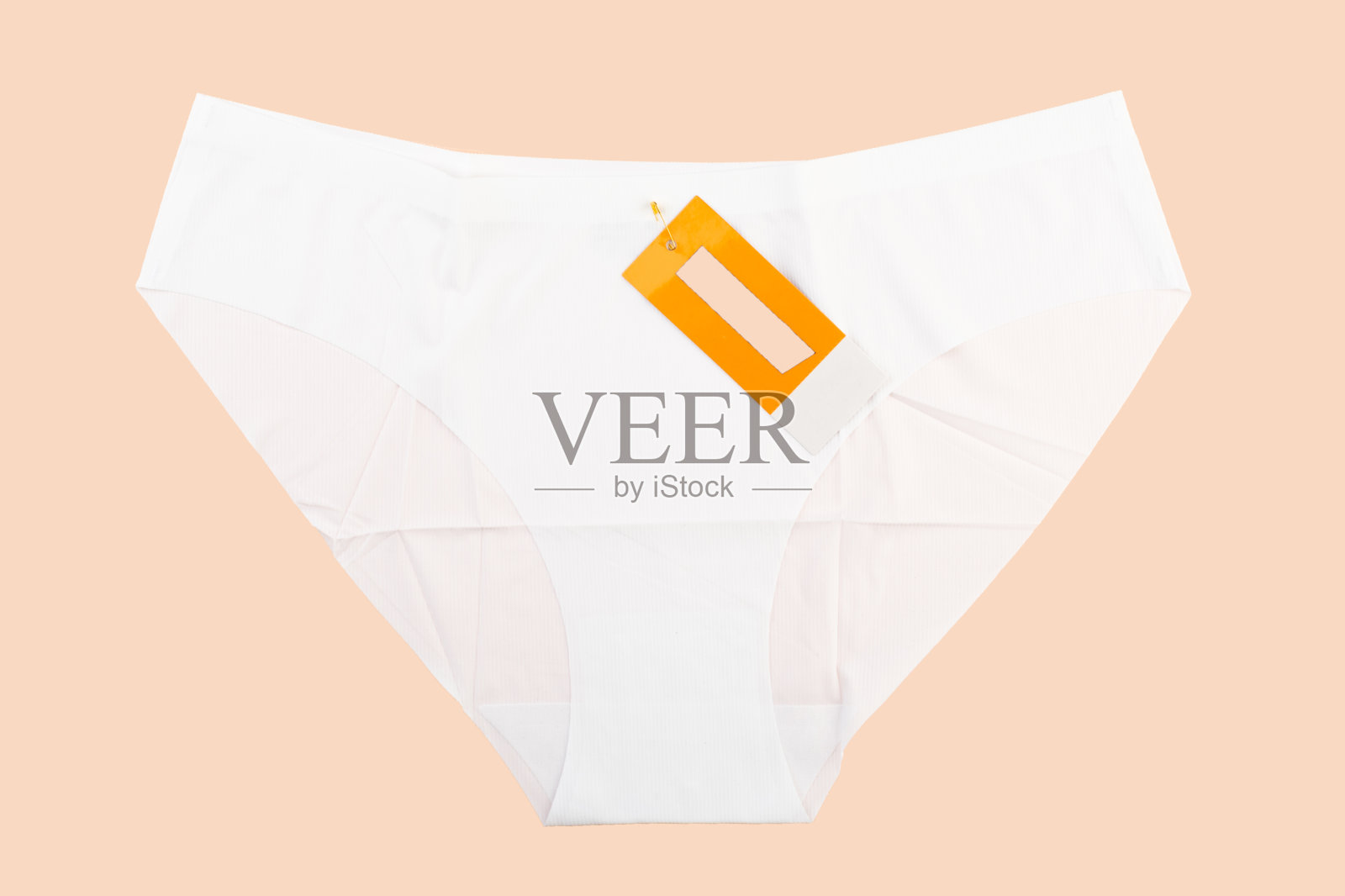 白色新女性内裤，浅米色背景上有文字标识。照片摄影图片