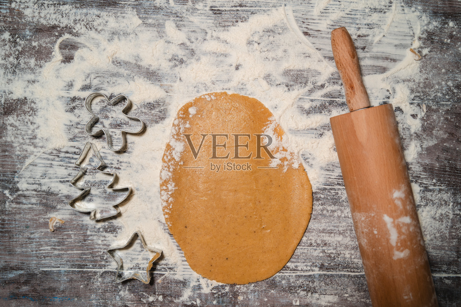 生的圣诞饼干。用饼干切刀制作姜饼的过程。照片摄影图片