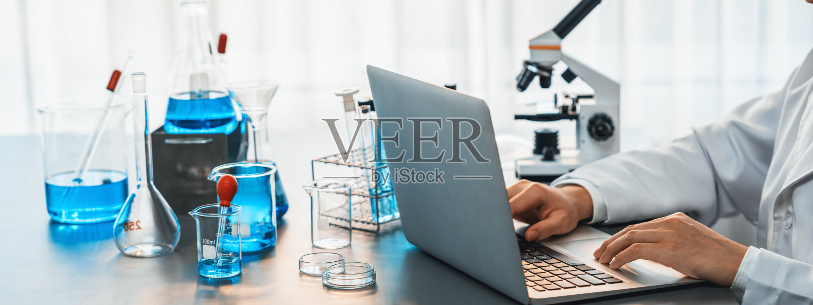 科学家在实验室用笔记本电脑进行化学实验。近代照片摄影图片