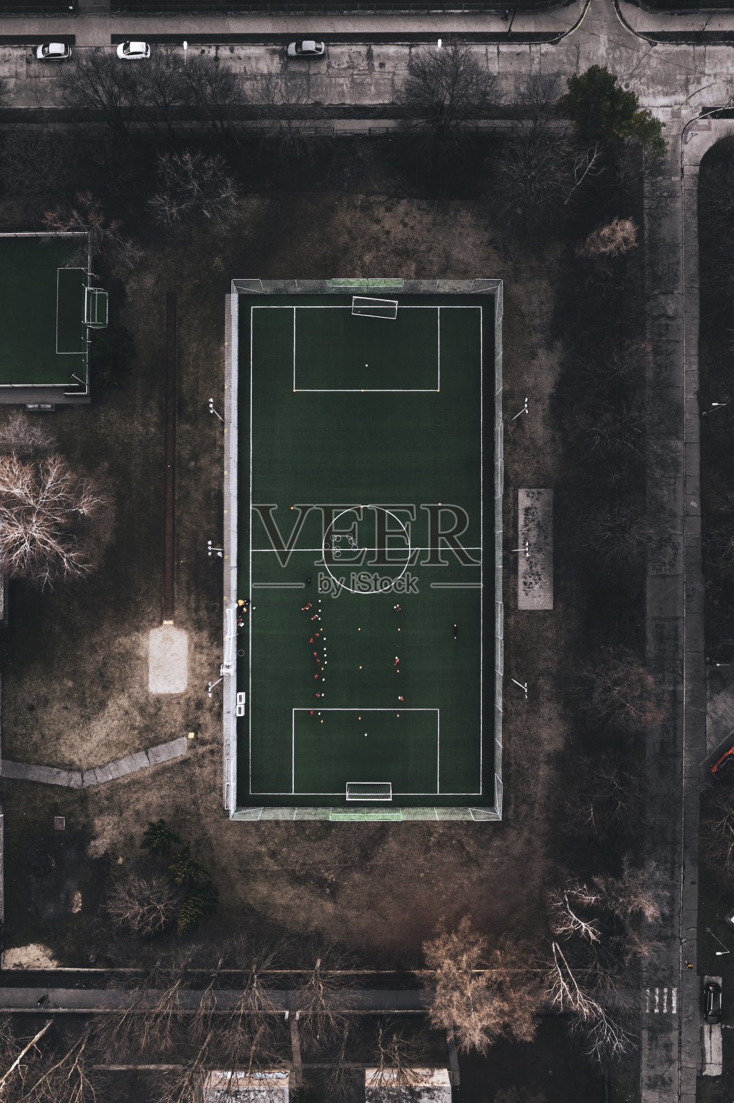 城市中一个小型训练足球场的俯视图。在没有雪的寒冷冬日里，城市里有人造草皮的足球场。照片摄影图片