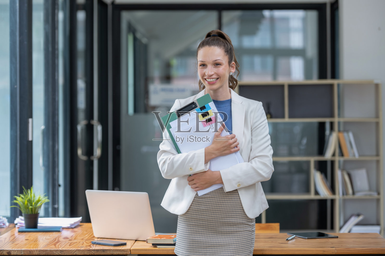 一位女商人拿着一份文件站在那里照片摄影图片