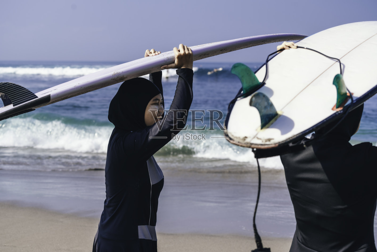 两个穆斯林妇女准备在黎明时分去冲浪照片摄影图片