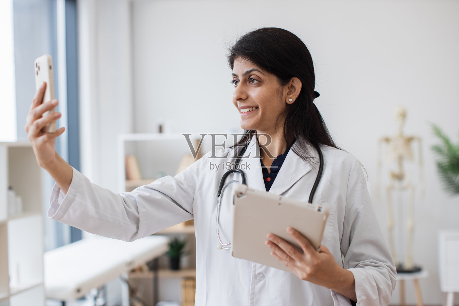 印度医生使用平板电脑和手机进行在线咨询照片摄影图片