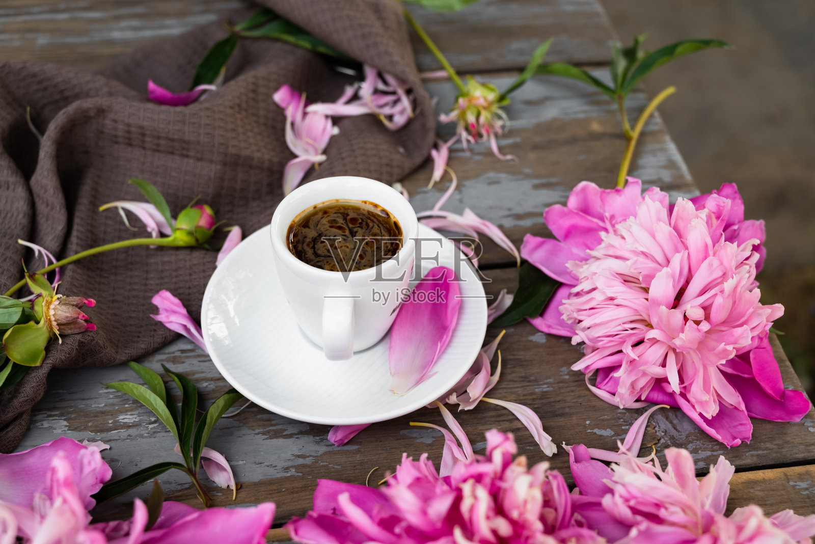 白色背景上的粉红色牡丹花和一杯咖啡。清晨，春天，时尚构图。平铺，俯视图，复制空间。照片摄影图片