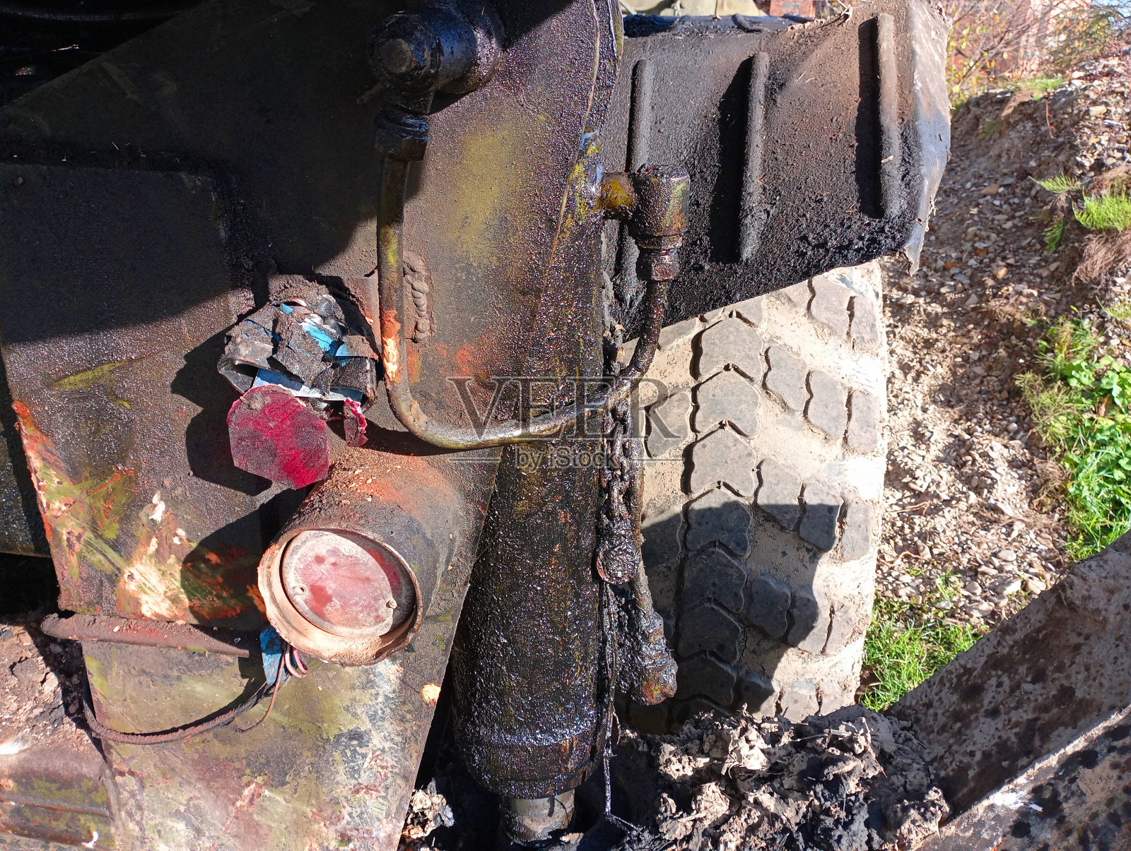 液压油漏到卡车的支腿上了。那辆绿色卡车后面的车胎坏了。大型工业车辆照片摄影图片