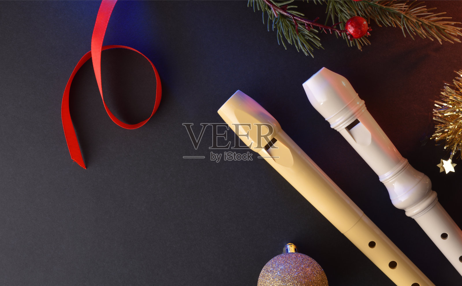 两个传统的塑料笛子放在黑色的桌子上，带有圣诞装饰照片摄影图片