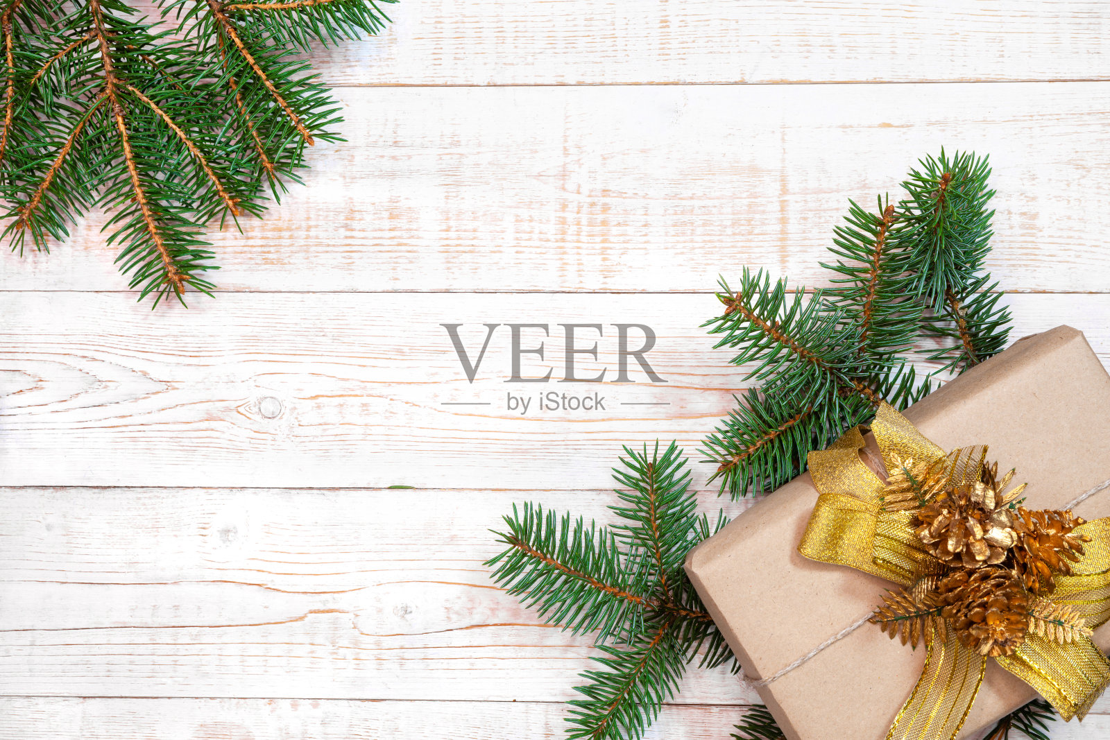 圣诞背景——冷杉树枝和礼盒放在白色的木桌上。平面布局，顶部视图合成边界与复制空间照片摄影图片
