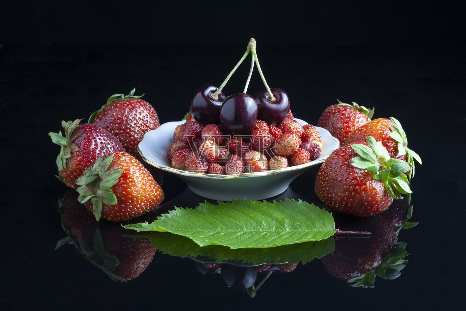 标题
桌上有一个白色盘子里的野草莓和樱桃照片摄影图片