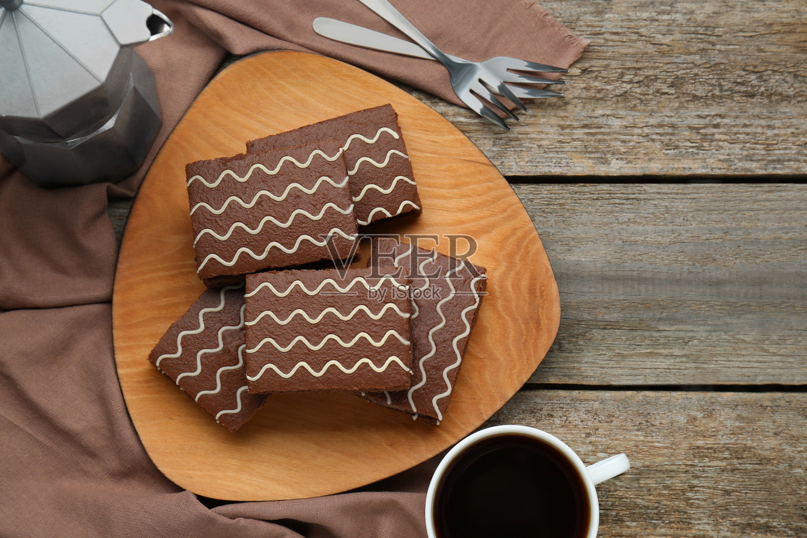 美味的巧克力海绵蛋糕和热饮放在木桌上，平躺着。文本空间照片摄影图片