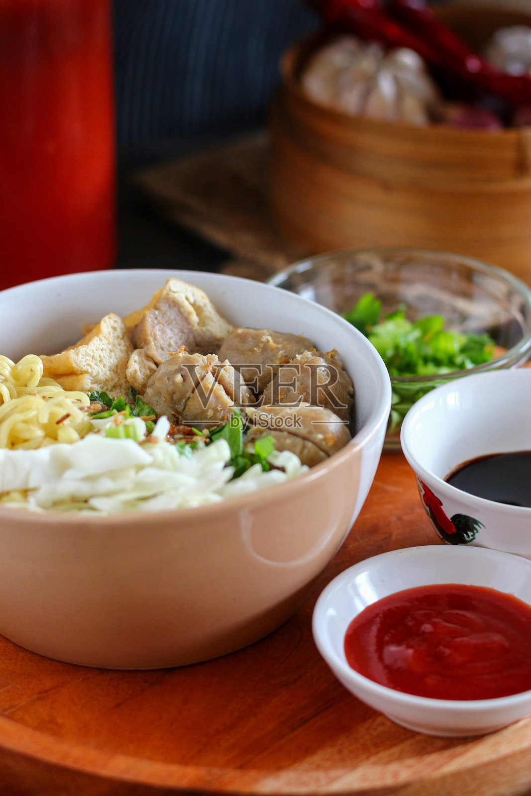 印尼肉丸(bakso)，配番茄和酱油。照片摄影图片