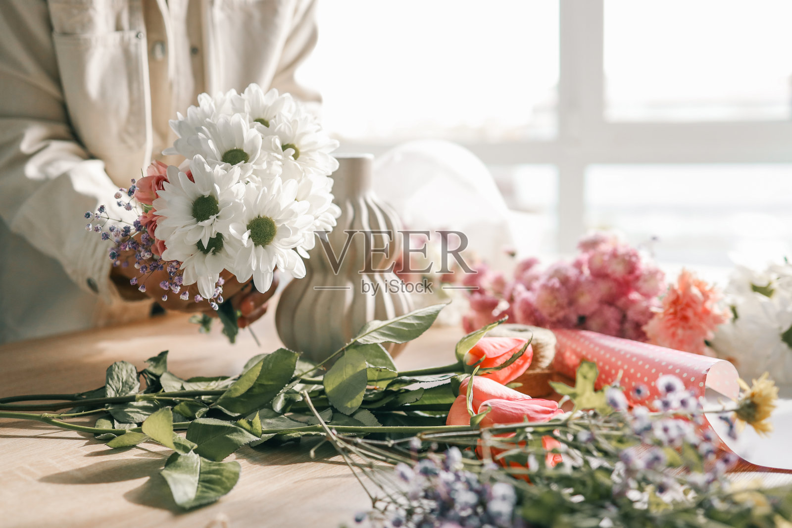花店老板上班了。制作秋季花卉装饰的妇女照片摄影图片
