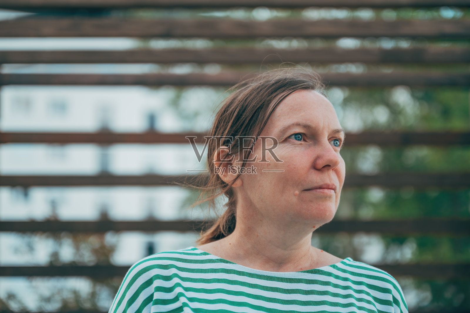 严肃的女性头像，梳着小马尾辫，望向远方照片摄影图片