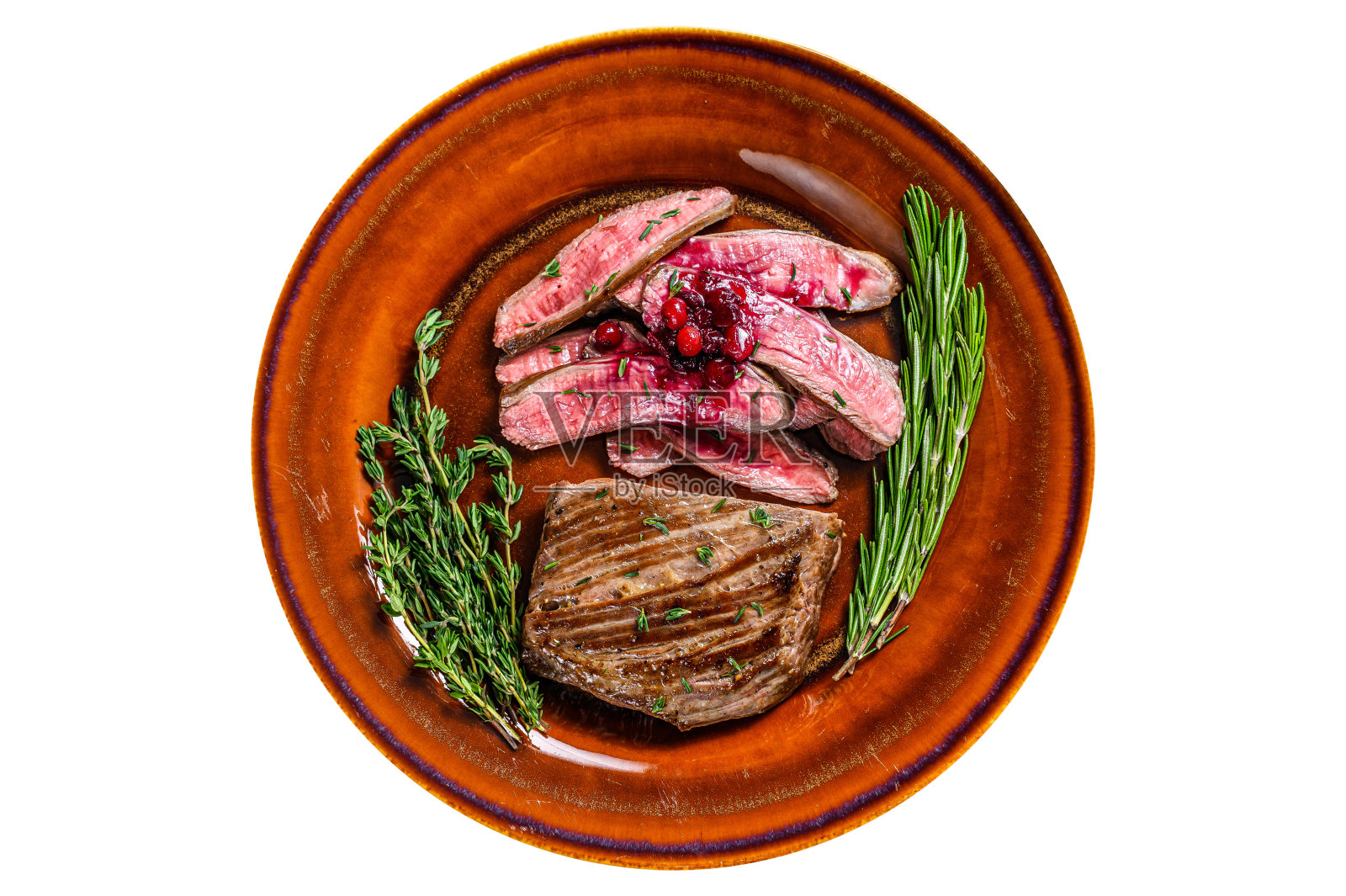 在盘子里煎成薄片的牛腩肉或牛肉排。孤立在白色背景上。照片摄影图片