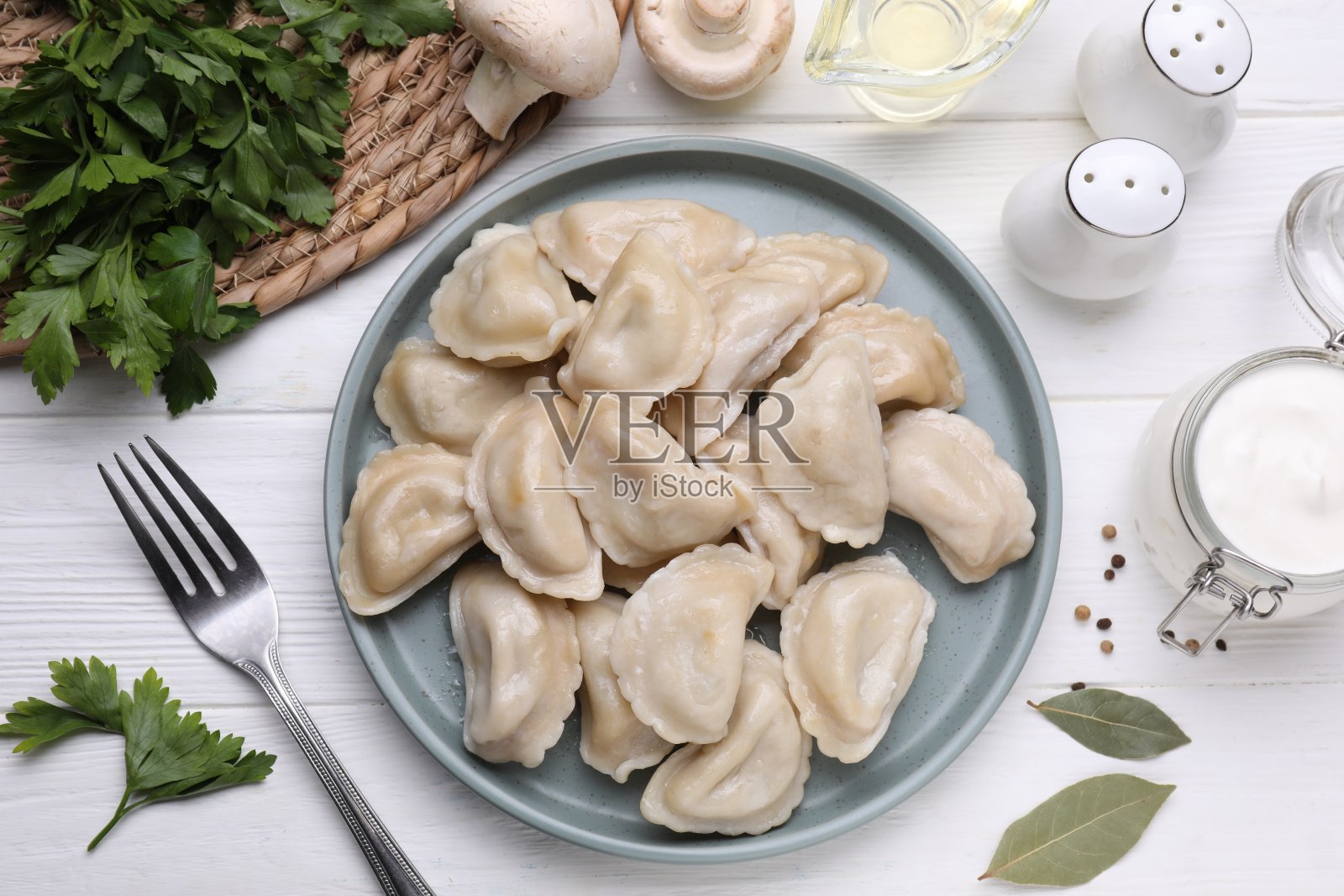 美味的土豆饺子(varenyky)放在白色的木桌上，平铺着照片摄影图片