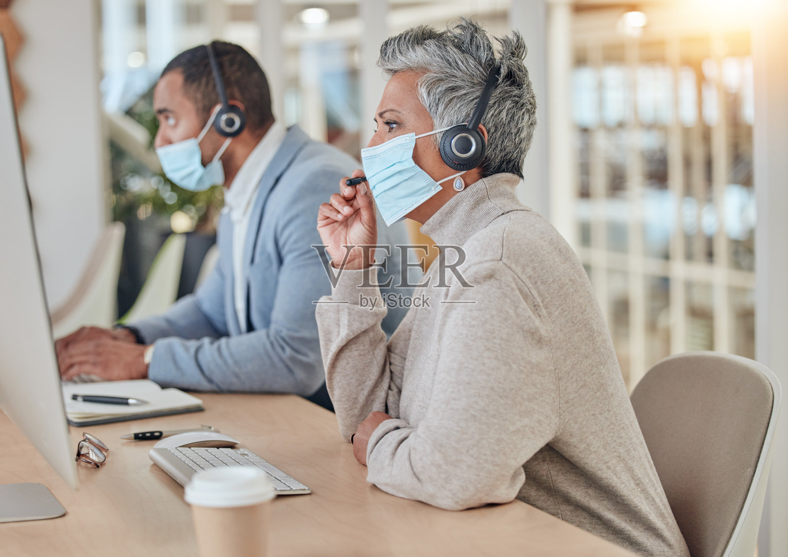 呼叫中心，戴口罩，与办公室的商务女性沟通，进行客户服务，咨询或建议。保健，病毒和细菌与员工联系，帮助台或卫生照片摄影图片