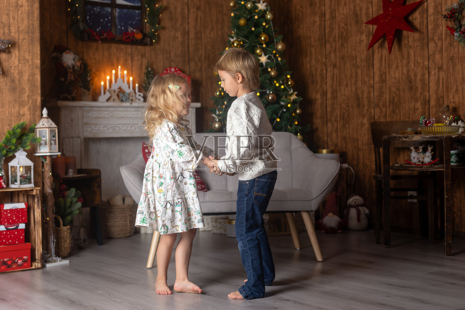 漂亮的孩子们，金发碧眼的孩子们，兄弟姐妹们，在装饰过的家里玩耍过圣诞节，享受假期照片摄影图片