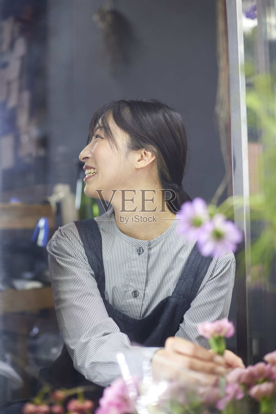 一位在花店系着围裙的日本妇女照片摄影图片