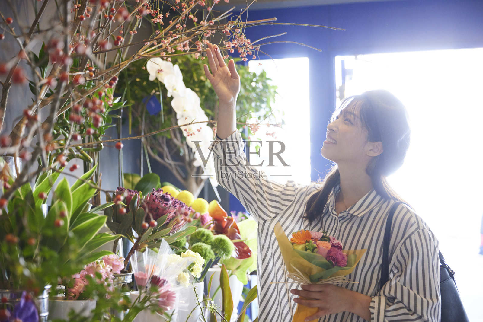 一位30多岁的日本妇女在花店购物照片摄影图片