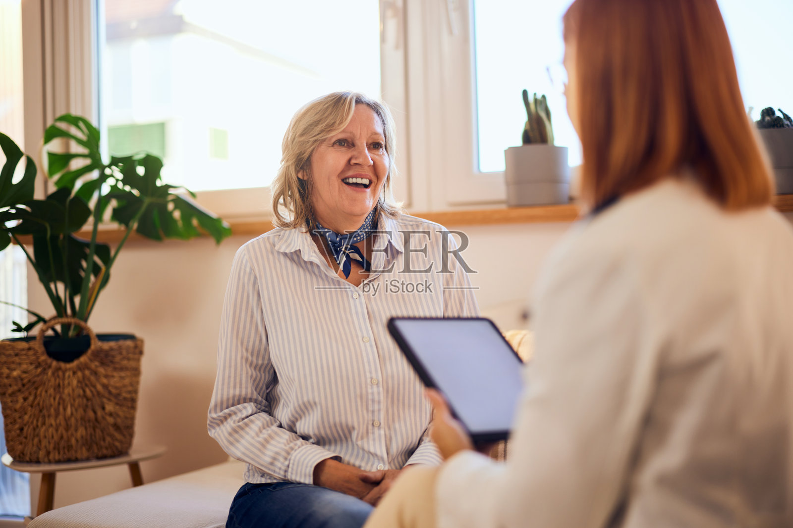 一个快乐的病人在医生的预约中，坐着谈论她更好的心理健康。照片摄影图片