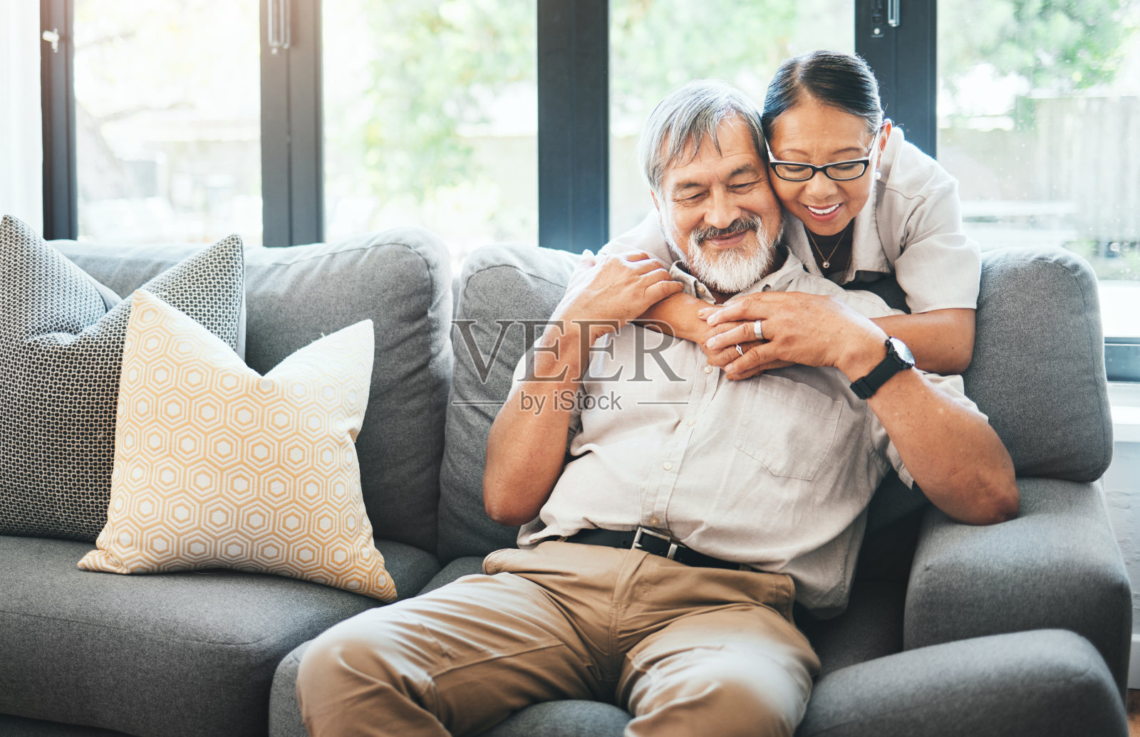回家，拥抱和老夫妇在沙发上，婚姻和爱情与退休，微笑和承诺。公寓，年长的男人或成熟的女人在沙发上，说话和支持与关系，拥抱或结合照片摄影图片