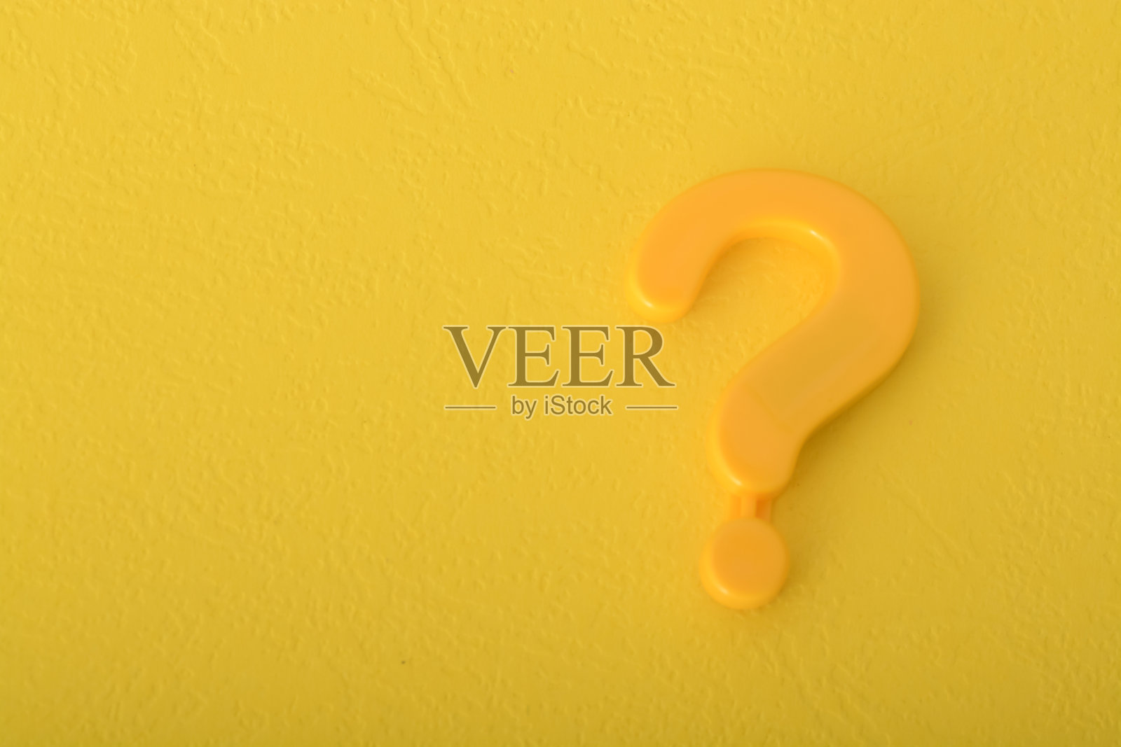 孤立在黄色背景上的问号符号就像一个灯塔，邀请人们进行询问和探索知识。照片摄影图片