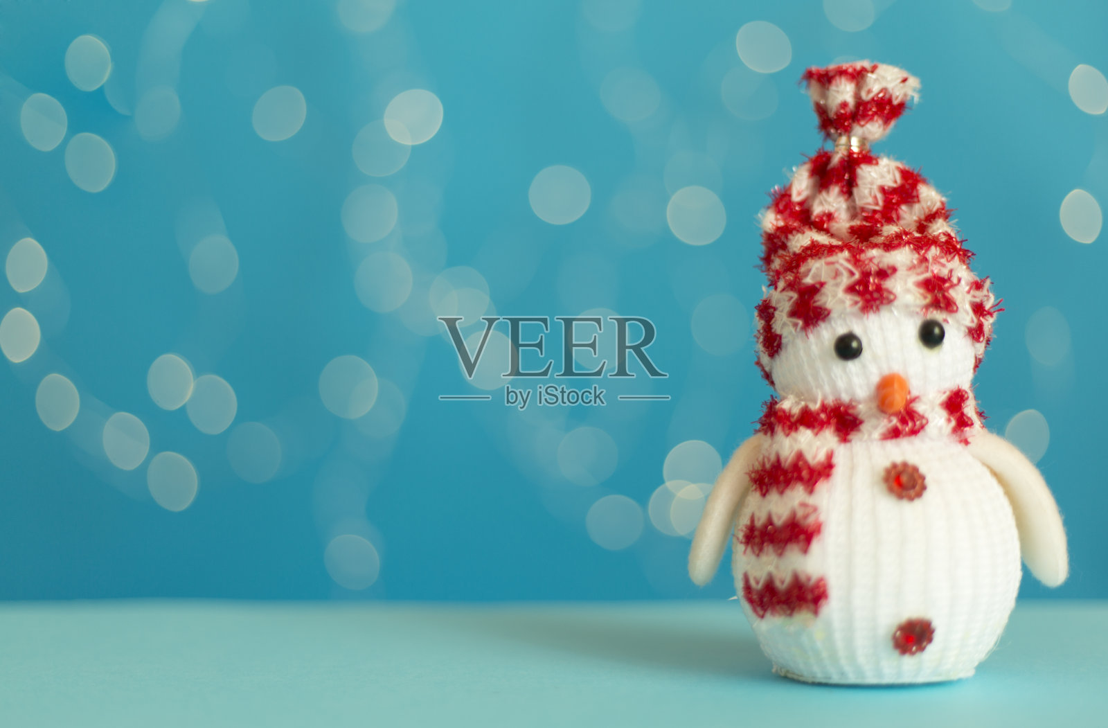 桌子上可爱的雪人，映衬着模糊的灯光照片摄影图片