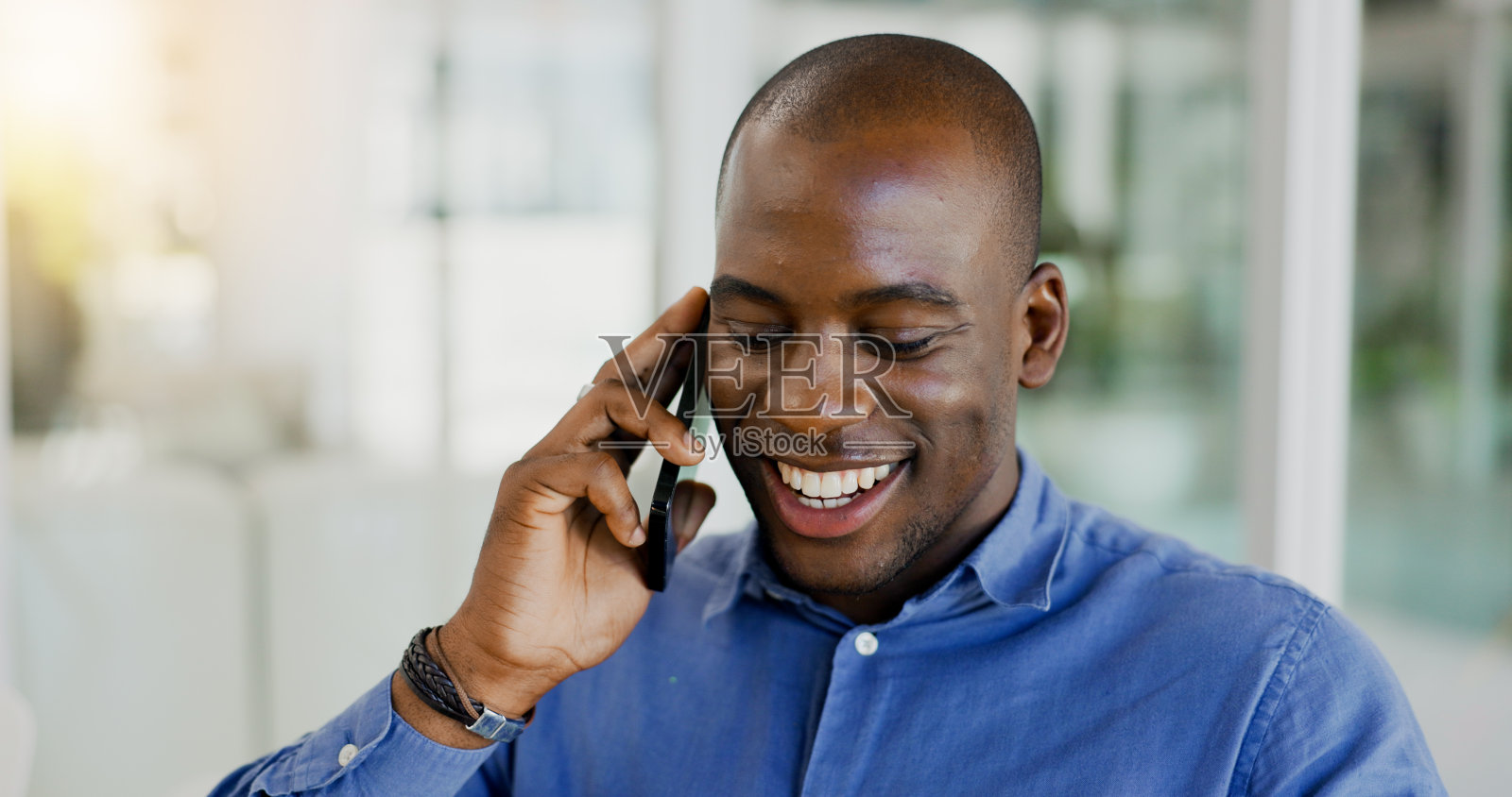 快乐的黑人，在办公室打电话、讨论、开玩笑或幽默时大笑。非洲商人微笑，说话或移动智能手机为有趣的商业对话或建议在工作场所照片摄影图片