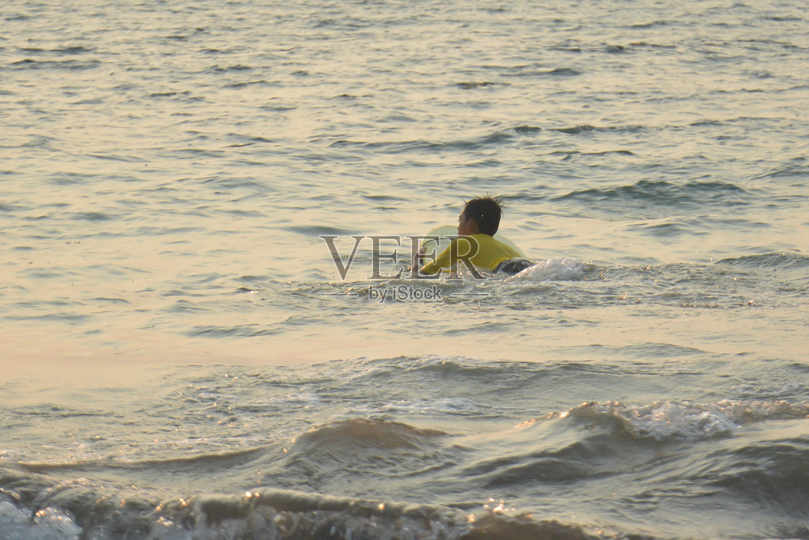 男孩在海里学习冲浪板照片摄影图片