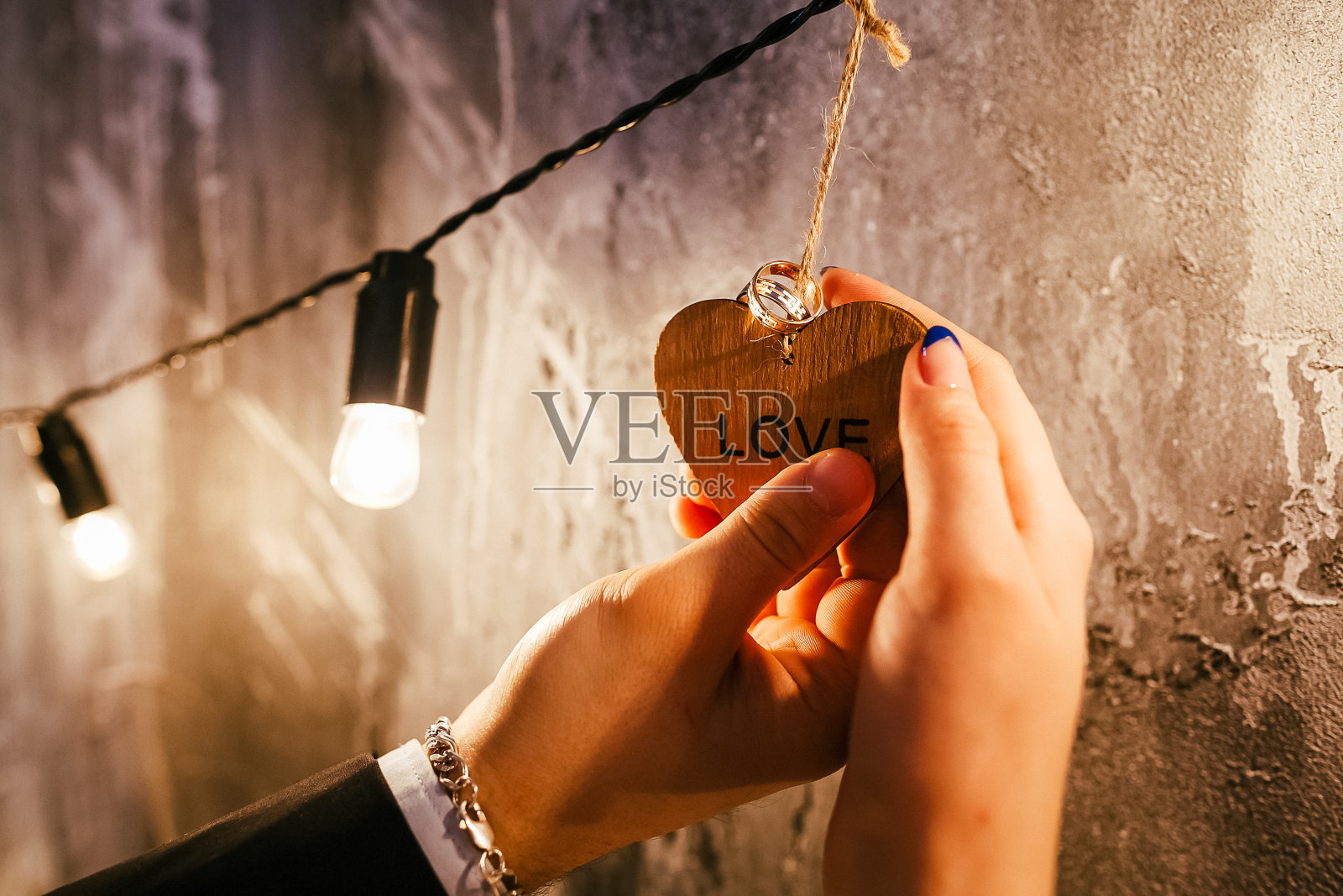 一男一女手中刻着爱的木心，浪漫的黄昏，两人之间的爱之光照片摄影图片