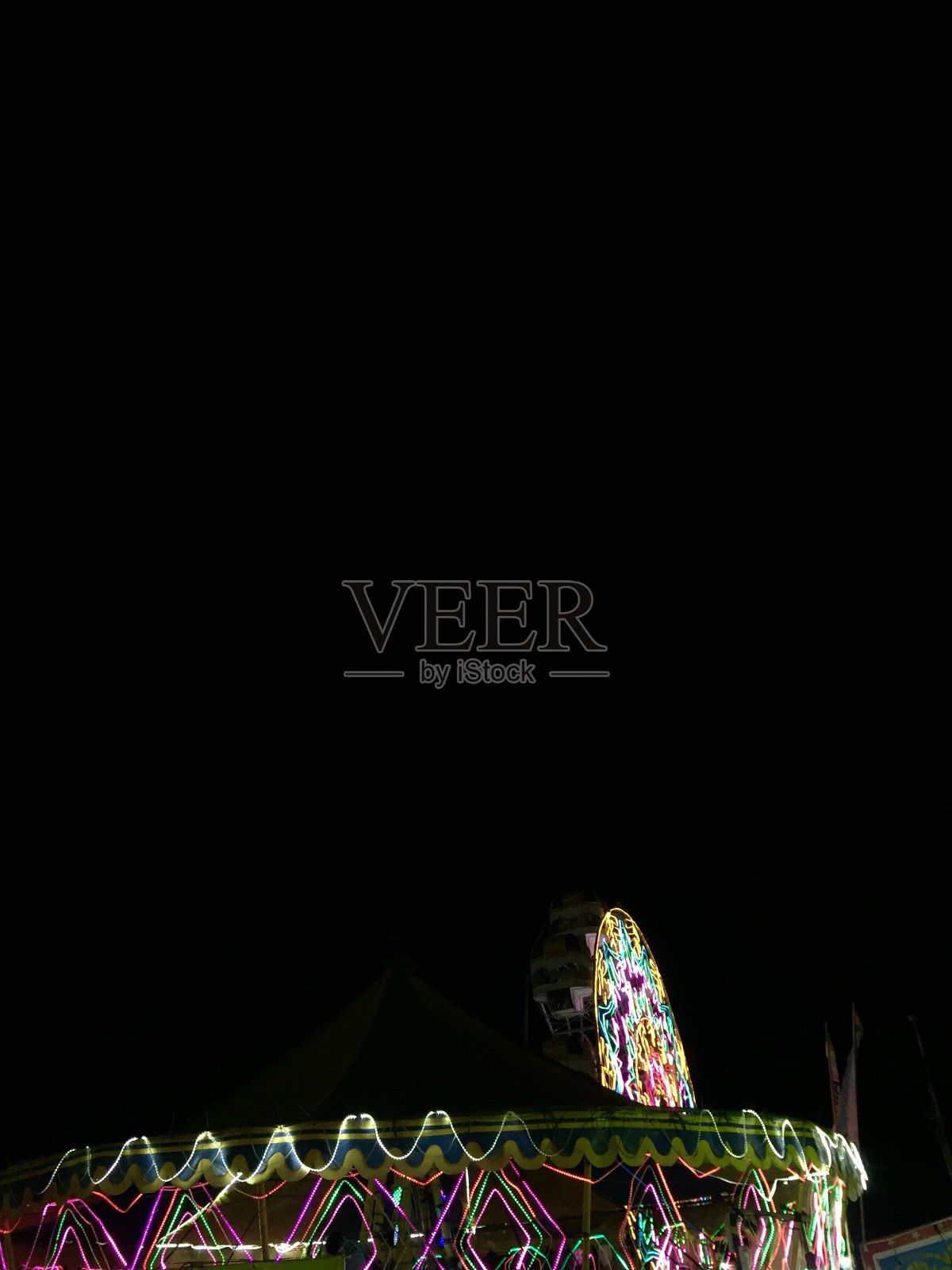 一个旋转木马和一个装饰着灯光的摩天轮照片摄影图片