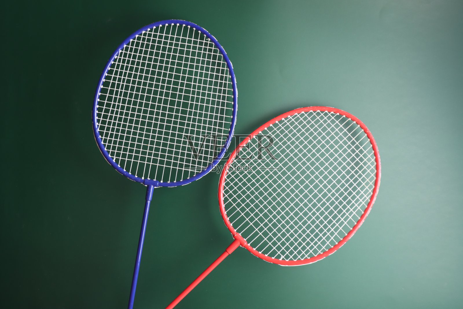 两个羽毛球运动员在深绿色的背景照片摄影图片